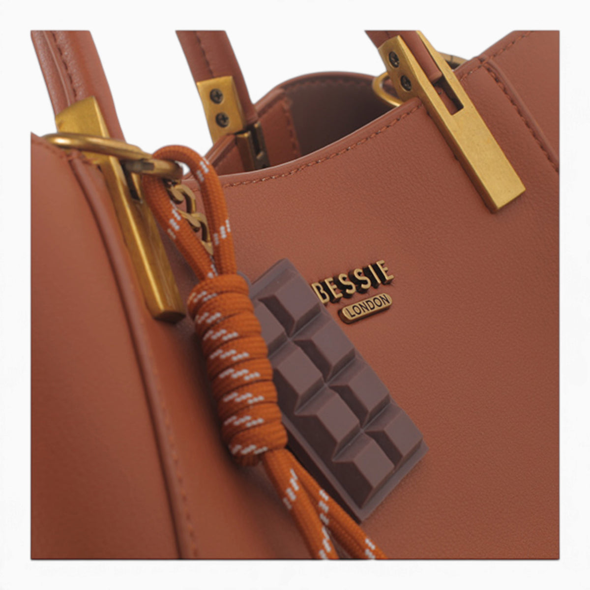 Tan faux leather tote bag, close-up of the chocolate bar charm