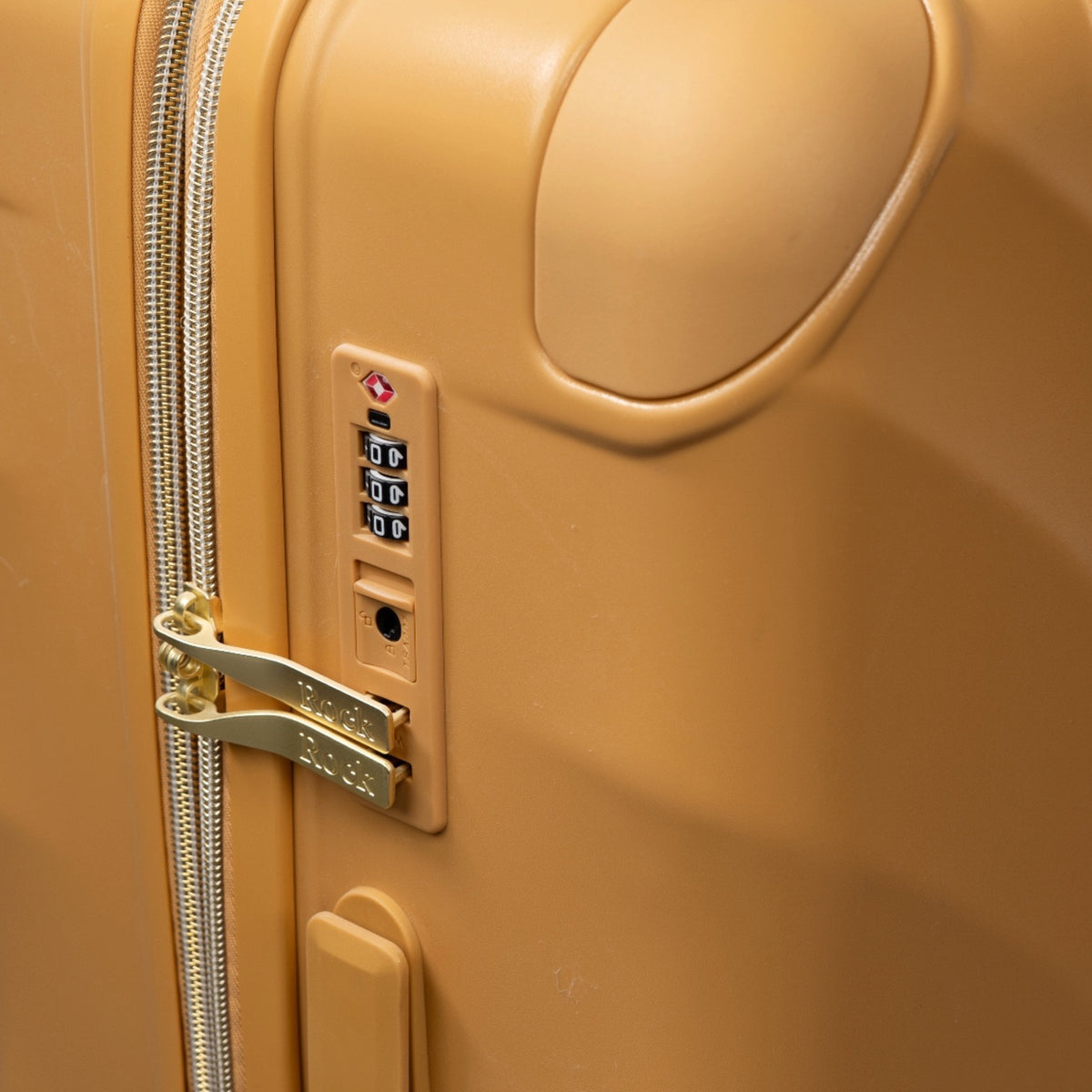 Gold Sunset Sahara suitcase, close-up of the TSA combination lock
