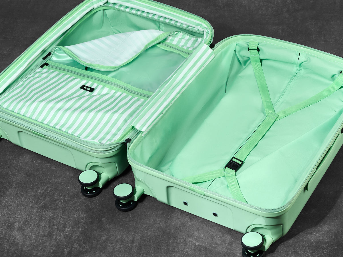 Pistachio Gelato suitcase opened to show the peach skin lining, wet pocket and packing straps