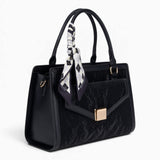 Black velvet-effect flap tote bag, angled view showing the flap top and scarf