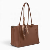 Tan knot handle shoulder bag, angled view showing the knot handle detail