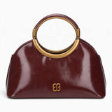Wine ring handle crossbody bag with a gold ring handle and rounded shape