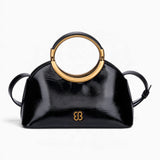 Black ring handle crossbody bag with a gold ring handle and rounded shape