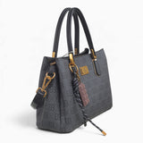 Black small monogram tote bag, angled view showing the monogram print and charm