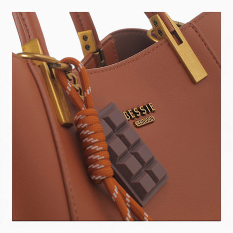 Tan faux leather tote bag, close-up of the chocolate bar charm
