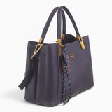 Purple faux leather tote bag, angled view showing the structured shape and charm