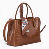 Tan croc-effect tote bag, angled view showing the glossy croc-effect texture