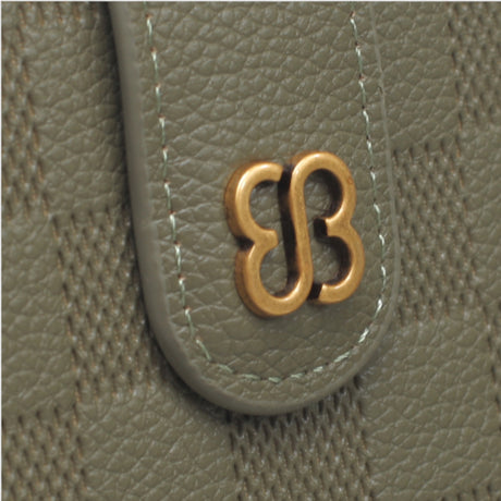 Green checkerboard flap wallet, close-up of the embossed checkerboard and gold-tone logo