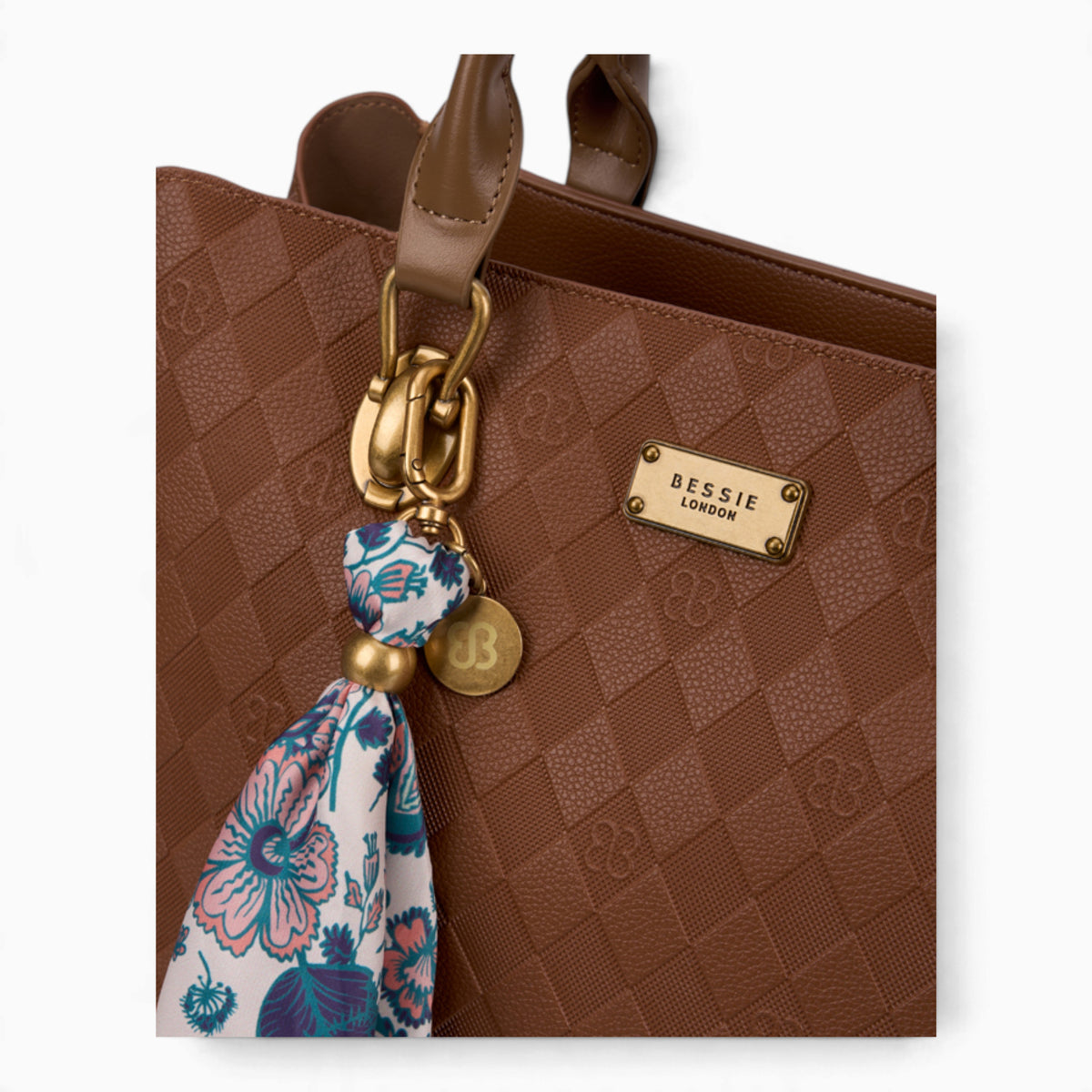 Tan monogram tote bag, close-up of the printed scarf and gold-tone charm
