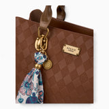 Tan monogram tote bag, close-up of the printed scarf and gold-tone charm