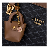 Black sculpted monogram tote bag, close-up of the mini bag charm and monogram print