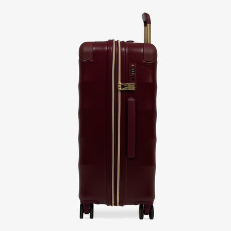 Burgundy Dusk Sahara medium suitcase, side view showing the side handle and reinforced corners