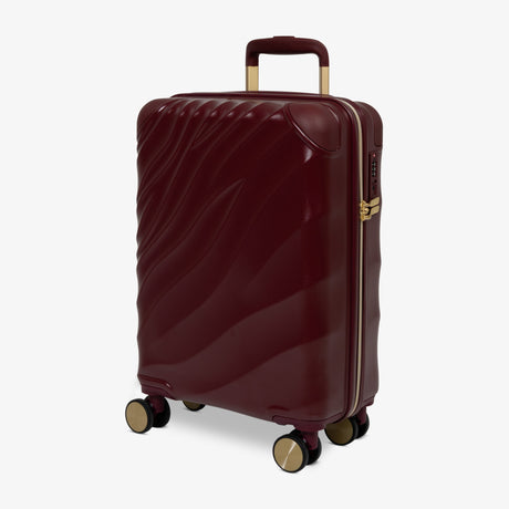 Burgundy Dusk Sahara cabin suitcase, angled view showing the wave-design shell
