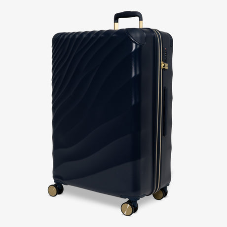 Midnight Navy Sahara large suitcase, angled view showing the wave-design shell