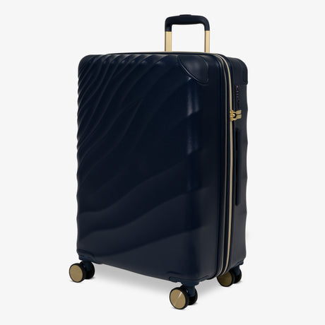 Midnight Navy Sahara medium suitcase, angled view showing the wave-design shell
