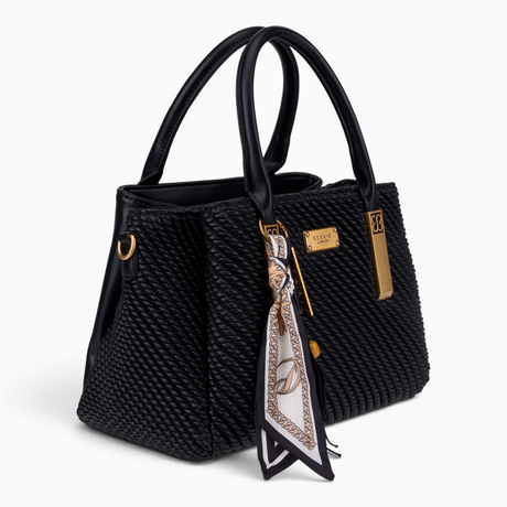 Black quilted tote bag, angled view showing the quilted texture and scarf charm