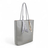 Bag Shack Bessie grey faux leather tote bag with a decorative scarf and pearl charm, side view