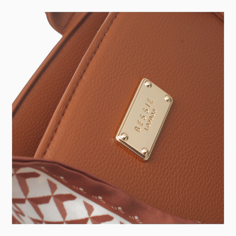 Tan large faux leather tote bag, close-up of the gold-tone logo plaque