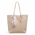 Bag Shack Bessie taupe faux leather tote bag with a decorative patterned scarf, pearl charm, and zip-top closure.